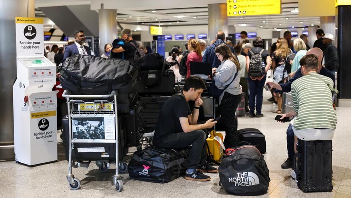 A British Airways staff member speaks to passengers at Heathrow Airport, as Britains National Air Traffic Service (NATS) restricts UK air traffic due to a technical issue causing delays, in London, Britain, August 28, 2023. REUTERS/Hollie Adams
