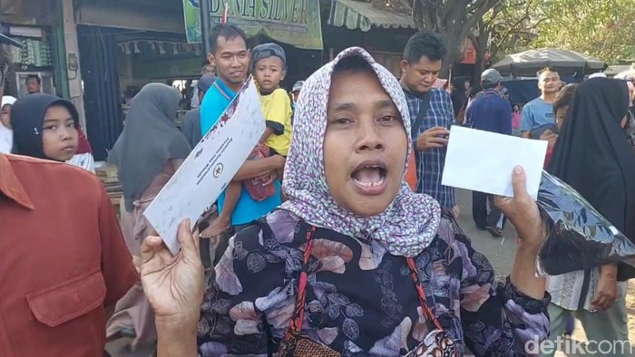 Seorang pedagang di Pekalongan, Ana, memperlihatkan amplop dari Jokowi dan Iriana, Selasa (29/8/2023).