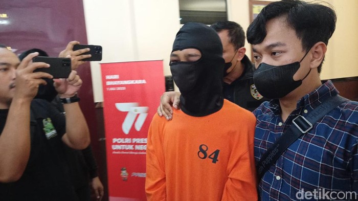 Tetangga penjudi yang menusuk suami istri di Tebet, Jaksel, berbaju tahanan dan diborgol.
