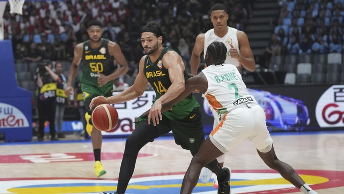 Brazil forward Leonardo Meindl (14) dribbles the ball against Ivory Coast guard Bazoumana Kone (2) during the Basketball World Cup group G match between Brazil and the Ivory Coast at the Indonesia Arena stadium in Jakarta, Indonesia, Wednesday, Aug. 30, 2023. (AP Photo/Tatan Syuflana)