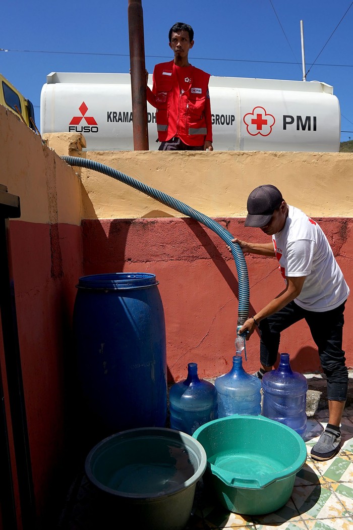 Seorang warga menutup ember dan galon air miliknya usai diisi oleh petugas Palang Merah Indonesia (PMI) di Desa Buata, Kabupaten Bone Bolango, Gorontalo, Rabu (30/8/2023). PMI Provinsi Gorontalo dan Kabupaten Bone Bolango mulai mendistribusikan air bersih di dua desa dari lima desa yang terdampak kekeringan dan membutuhkan bantuan air. ANTARA FOTO/Adiwinata Solihin/aww.