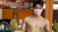 Demi mencari biaya kuliah, pemuda 19 tahun di Kuala Lumpur ini pilih jualan durian di pinggir jalan. Sosoknya bernama Ashton yang juga bertelanjang dada saat jualan. Foto: Facebook Muscle Durian