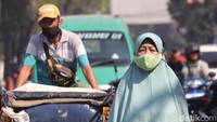 Tak hanya pengendara motor, pejalan kaki juga turut menggunakan masker saat beraktivitas di luar rumah. (Foto: Wisma Putra/detikJabar)