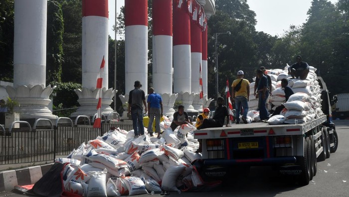 Sejumlah pekerja mengangkat beras Bulog dari jalanan ke atas truk saat evakuasi di kawasan Tugu Kujang, Kota Bogor, Jawa Barat, Rabu (30/8/2023). Truk yang mengangkut ratusan karung beras Bulog terguling dan menutupi badan jalan akibat kelebihan muatan pada Rabu (30/8/2023) dini hari sehingga Satlantas Polresta Bogor Kota melakukan pengalihan arus lalu lintas. ANTARA FOTO/Arif Firmansyah/aww.