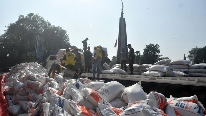 Sejumlah pekerja mengangkat beras Bulog dari jalanan ke atas truk saat evakuasi di kawasan Tugu Kujang, Kota Bogor, Jawa Barat, Rabu (30/8/2023). Truk yang mengangkut ratusan karung beras Bulog terguling dan menutupi badan jalan akibat kelebihan muatan pada Rabu (30/8/2023) dini hari sehingga Satlantas Polresta Bogor Kota melakukan pengalihan arus lalu lintas. ANTARA FOTO/Arif Firmansyah/aww.