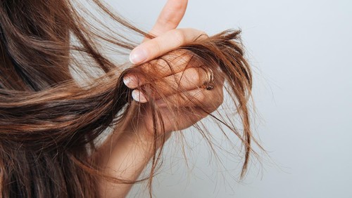Girl holding her hair in her hand. Hair care concept. Shampoo. Haircut needed.