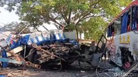 Tampak bodi bus Sugeng Rahayu ringsek parah dan atapnya juga ringsek sampai menyentuh ke aspal. Foto: Sugeng Harianto/detikJatim