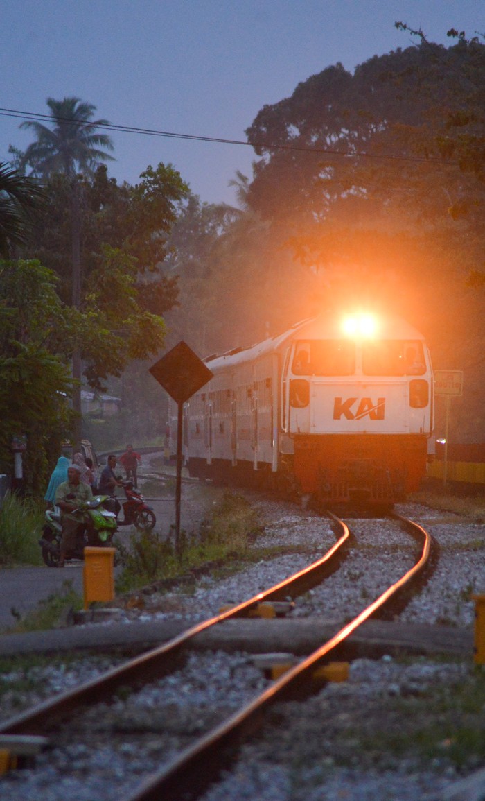 Pengendara motor menunggu kereta api lewat di perlintasan sebidang di Padang, Sumatera Barat, Rabu (30/8/2023). PT KAI Divre II Sumbar tahun ini menutup lima perlintasan sebidang yang liar di Padang dari total 112 perlintasan sebidang untuk meningkatkan keselamatan perjalanan kereta api. ANTARA FOTO/Iggoy el Fitra/nym.
