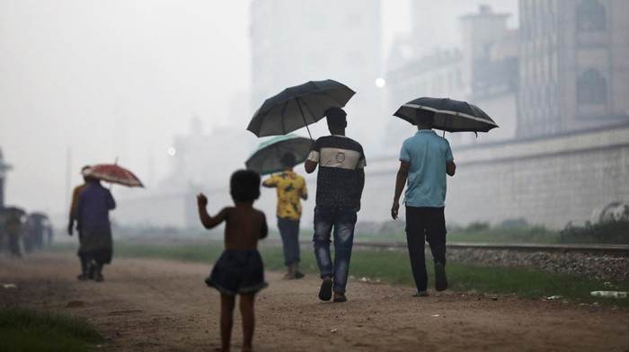 Potret Aktivitas Warga Dhaka Bangladesh di Tengah Kepungan Asap People sit on a rail track as smoke rises from steel mills near a slum in Dhaka, Bangladesh August 29, 2023. REUTERS/Mohammad Ponir Hossain