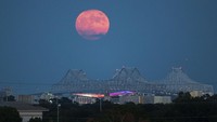 A Blue Supermoon rises behind the Crescent City Connection in New Orleans, Wednesday, Aug. 30, 2023. (David Grunfeld/The New Orleans Advocate via AP)