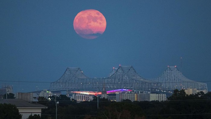 A Blue Supermoon rises behind the Crescent City Connection in New Orleans, Wednesday, Aug. 30, 2023. (David Grunfeld/The New Orleans Advocate via AP)