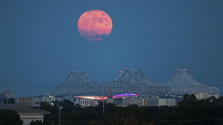 A Blue Supermoon rises behind the Crescent City Connection in New Orleans, Wednesday, Aug. 30, 2023. (David Grunfeld/The New Orleans Advocate via AP)
