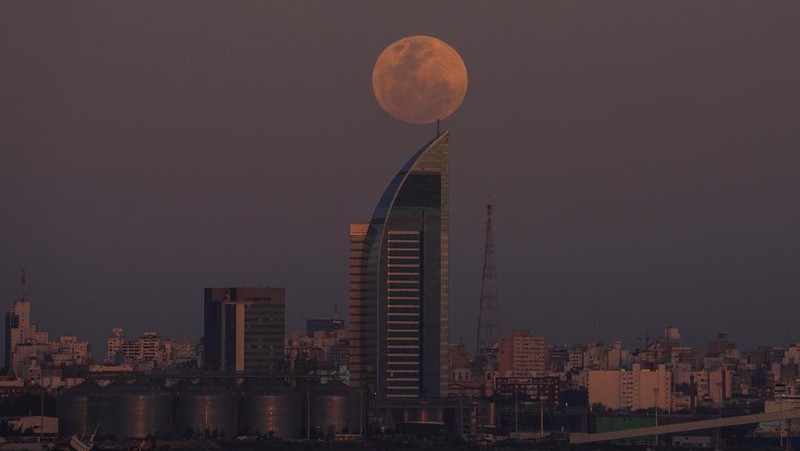 A supermoon rises over Montevideo, Uruguay, Wednesday, Aug. 30, 2023. The cosmic curtain rose Wednesday night with the second full moon of the month, also known as a blue moon. (AP Photo/Matilde Campodonico)