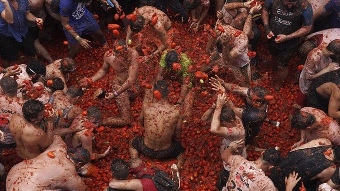 Revellers throw tomatoes at each other during the annual 