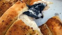 Beli pizza buat dimakan di rumah, pembeli ini hampir saja tersedak sarung tangan latex yang ada di dalam roti pizza. Foto: Site News