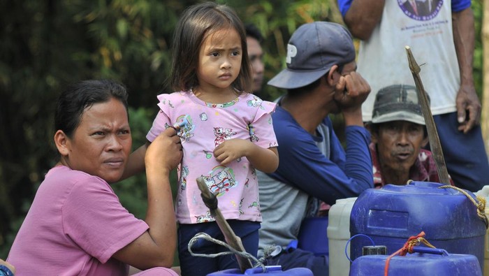 Sejumlah warga usai mengambil bantuan air bersih di Desa Ridogalih, Cibarusah, Kabupaten Bekasi, Jawa Barat, Jumat (1/9/2023). Pemerintah setempat meningkatkan status Siaga Darurat bencana menjadi tanggap darurat kekeringan karena 23 desa di sembilan kecamatan dengan 6.675 Kepala Keluarga (KK) terdampak kekeringan. ANTARA FOTO/ Fakhri Hermansyah/rwa.