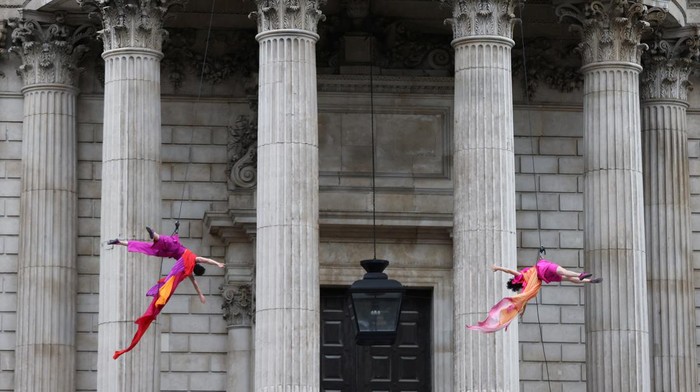 Members of the public watch dancers from vertical dance company BANDALOOP perform while suspended from St Paul's Cathedral, on the opening evening of the City of London's reimagined Bartholomew Fair, in London, Britain, August 31, 2023. REUTERS/Hollie Adams
