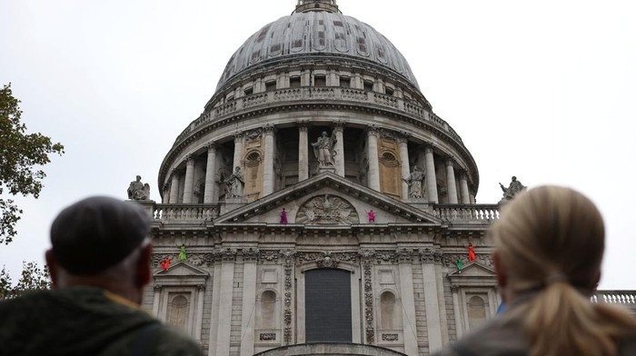 Members of the public watch dancers from vertical dance company BANDALOOP perform while suspended from St Paul's Cathedral, on the opening evening of the City of London's reimagined Bartholomew Fair, in London, Britain, August 31, 2023. REUTERS/Hollie Adams