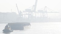 Kapal tongkang pengangkut batu bara melintasi Sungai Musi yang tertutup kabut asap di Palembang, Sumatera Selatan, Jumat (1/9/2023).   