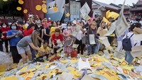 Masyarakat etnis Tionghoa melemparkan uang tiruan yang disebut uang neraka untuk dibakar sebagai persembahan, saat Festival Hantu Lapar di Medan, Sumatera Utara, Rabu (30/8/2023).