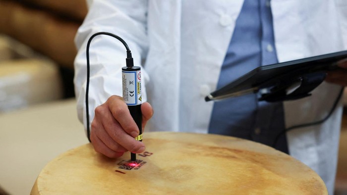 Gabriele Fontana checks a microchip inserted into a QR code label placed on a Parmesan cheese, a security system that is being tested to track and identify cheese forms, at 4 Madonne Caseificio in Modena, Italy August 31, 2023. REUTERS/Claudia Greco