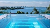 Di luar rumah, terdapat kolam renang besar yang cocok untuk bersantai menikmati iklim tropis Miami. Lokasinya yang terletak di sebuah pulau membuat para penghuninya dapat menikmati lanskap laut yang mengelilingi rumah ini 360 derajat dari semua arah dan sudut. 
