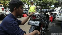 Petugas melakukan pengujian asap kendaraan bermotor.