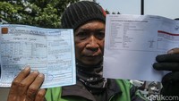 Seorang pengemudi ojek online terkena tilang usai mengikuti uji emisi di Dirlantas Polda Metro Jaya, Jakarta, Jumat (1/9/2023).  