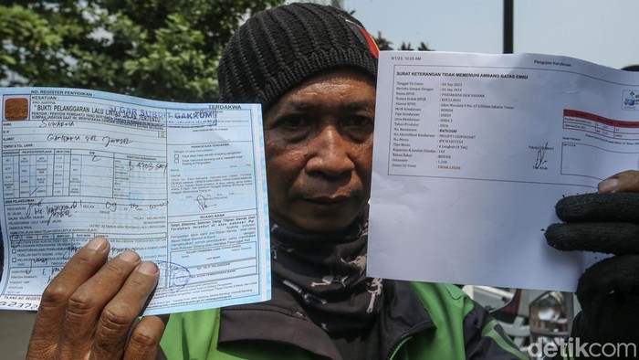Ojol Kena Tilang Uji Emisi, Denda Rp 250 Ribu Menanti Seorang pengemudi ojek online ditilang polisi usai dinyatakan tidak lulus uji emisi di Dirlantas Polda Metro Jaya, Jakarta, Jumat (1/9/2023).