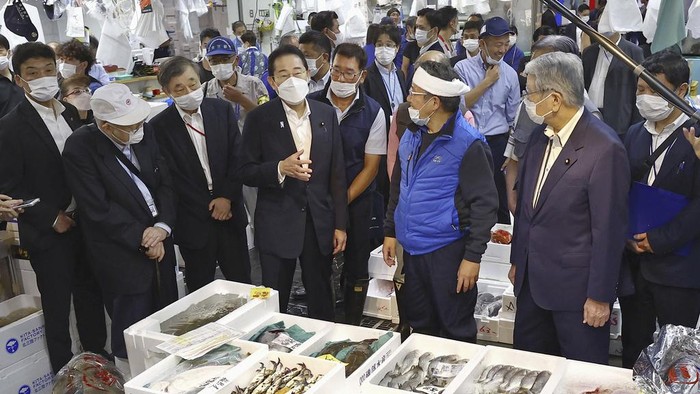 PM Jepang Makan Ikan Laut Fukushima di Tengah Polemik Limbah Nuklir Japan's Prime Minister Fumio Kishida, front left, tries a seafood at Toyosu fish market in Tokyo Thursday, Aug. 31, 2023. Kishida visited the fish market to highlight fish safety and assess the impact of China's ban on Japanese seafood. (Kyodo News via AP)