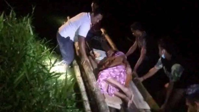 Seorang pasien di Kabupaten Pulau Morotai diseberangkan melalui sungai menggunakan rakit.