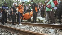 Petugas mengevakuasi jenazah perempuan yang terserempet kereta di perlintasan kereta Permata Hijau, Jakarta, Jumat (1/9/2023).  