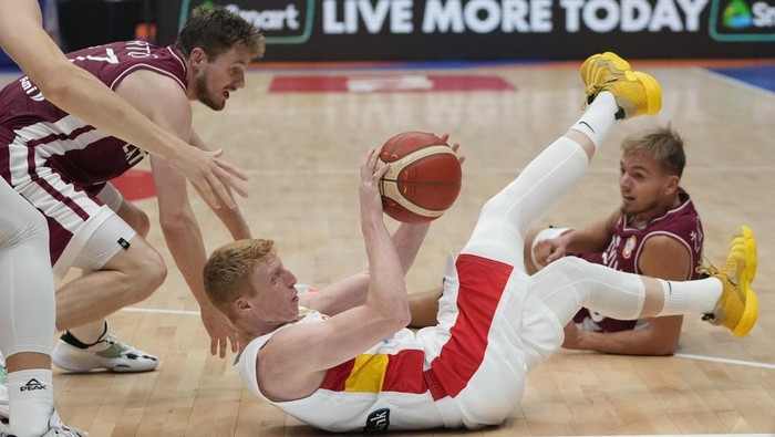 Spain guard Alberto Diaz (4), bottom, battles for the possession of the ball against Latvia guard Arturs Kurucs (47), left, and Latvia guard Arturs Zagars (55) during the Basketball World Cup second round match between Spain and Latvia at the Indonesia Arena stadium in Jakarta, Indonesia, Friday, Sept. 1, 2023. (AP Photo/Achmad Ibrahim)