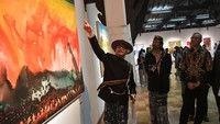 Budayawan Sujiwo Tejo menunjukkan salah satu lukisan yang dipamerkan kepada Ketua KPU Hasyim, Kamis (31/8/2023) malam.  