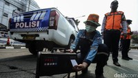 Petugas melakukan pengujian asap kendaraan dinas polisi.  