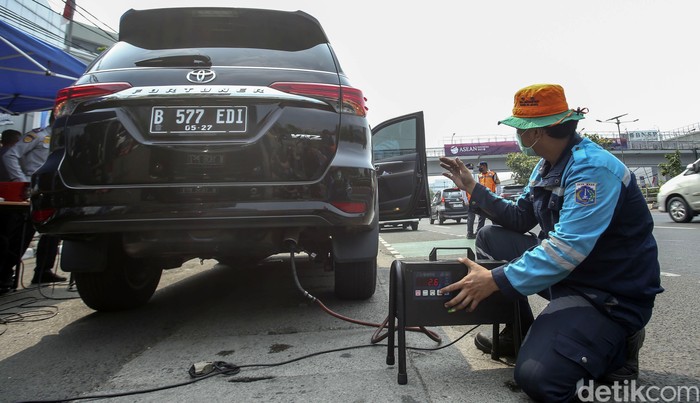 Polisi menilang pengendara mobil yang tidak lolos uji emisi di Depan Dirlantas Polda Metro Jaya, Jakarta, Jumat (1/9/2023). Polda Metro Jaya hari ini mulai menggelar razia kendaraan bermotor untuk mengikuti uji emisi. Kendaraan yang tak mengikuti atau tak lulus uji emisi akan dikenakan sanksi tilang yang akan menyesuaikan standar prosedur yang berlaku.