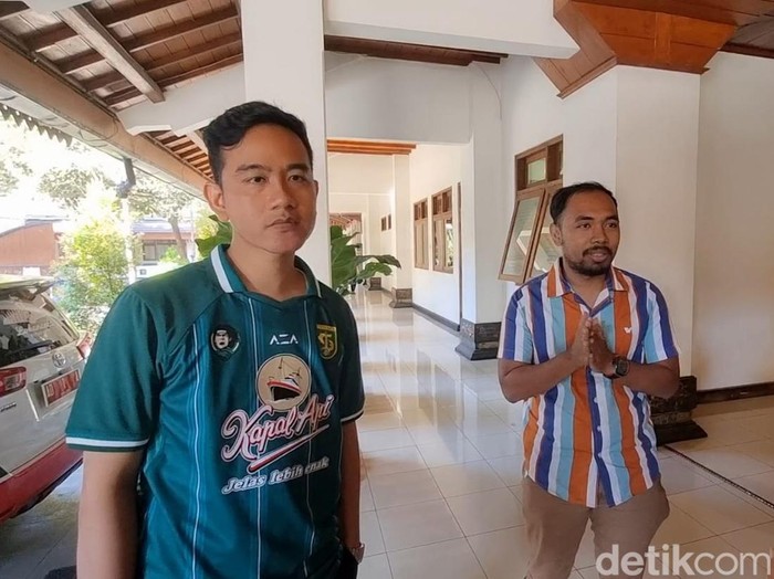 Wali Kota Solo Gibran Rakabuming Raka mengenakan jersey Persebaya Surabaya di Balai Kota Solo, Jumat (1/9/2023).