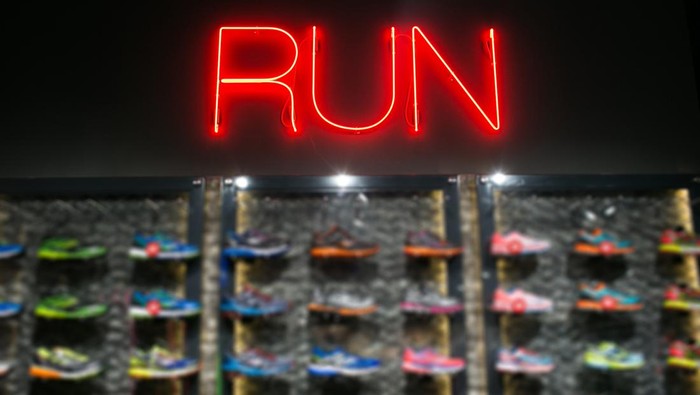Trendy casual running shoes on dark background. Run, colorful poster