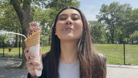 Momen kuliner serunya juga terlihat ketika menikmati es krim di sebuah taman. Aaliyah membeli es krim dengan taburan cokelat meisjes warna-warni. Foto: Instagram @aaliyah.massaid