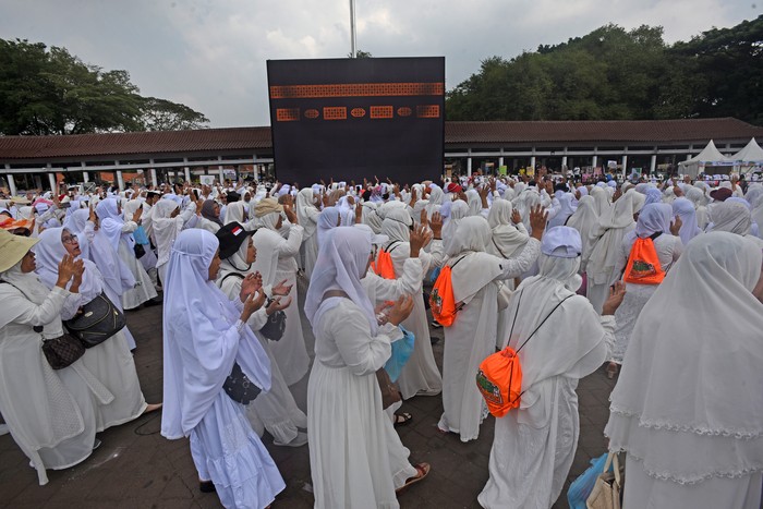 Sejumlah warga melambaikan tangan ke arah replika kabah saat mengikuti bimbingan manasik ibadah umroh di Alun-alun Kota Serang, Banten, Sabtu (2/9/2023). Manasik tersebut digelar Kanwil Kemenag Banten bekerjasama dengan operator perjalanan haji dan umroh. ANTARA FOTO/Asep Fathulrahman/ hp.