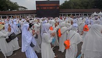 Sejumlah warga berjalan mengelilingi replika kabah saat mengikuti bimbingan manasik ibadah umroh di Alun-alun Kota Serang, Banten.
