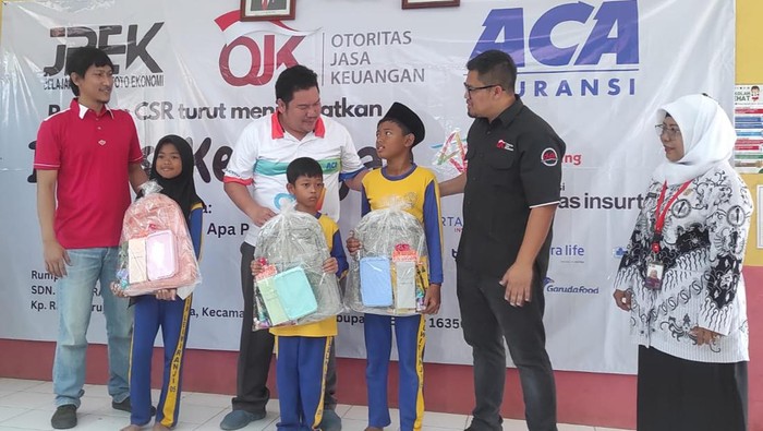 Momen Anak-anak Sekolah Belajar Literasi Keuangan Analis Senior Deputi Direktur Pelaksanaan Edukasi Keuangan OJK Arinengwang Gusta Galung Raharjo (kedua kanan) bersama Kepala Sekolah SDN Leuwiranji Supriyati (kanan) Kepala Divisi Media dan Marketing Communication PT Asuransi Central Asia (ACA), Sugiarto (kedua kiri) dan MarCom Dept Head PT Asuransi Bintang Tbk Putu Saputro, menyapa siswa sekolah dasar selepas menyerahkan bantuan perlengkapan sekolah, di SDN Leuwiranji 05 Rumpin, Bogor, Jawa Barat , Sabtu (2/9/2023).