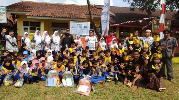 Analis Senior Deputi Direktur Pelaksanaan Edukasi Keuangan OJK Arinengwang Gusta Galung Raharjo (kedua kanan) bersama Kepala Sekolah SDN Leuwiranji Supriyati (kanan) Kepala Divisi Media dan Marketing Communication PT Asuransi Central Asia (ACA), Sugiarto (kedua kiri) dan MarCom Dept Head PT Asuransi Bintang Tbk Putu  Saputro, menyapa siswa sekolah dasar selepas menyerahkan bantuan perlengkapan sekolah, di SDN Leuwiranji 05 Rumpin, Bogor, Jawa Barat , Sabtu (2/9/2023).