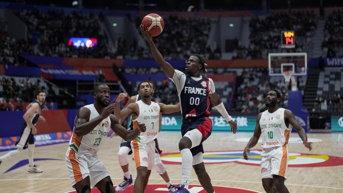 France guard Sylvain Francisco (00) shoots over Ivory Coast center Cedric Bah (23), forward Charles Abouo (1), and guard Solo Diabate (10) during the Basketball World Cup classification match between Ivory Coast and France at the Indonesia Arena stadium in Jakarta, Indonesia, Saturday, Sept. 2, 2023. (AP Photo/Dita Alangkara)