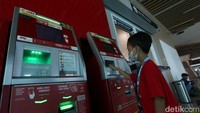 Salah satu anak mencoba untuk mengisi kartu kereta menggunakan mesin.