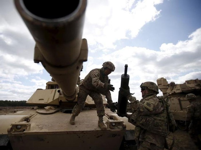 Members of the U.S. 2nd Battalion, 7th Infantry Regiment, 1st Brigade Combat Team, 3rd Infantry Division get ammunition to the Abrams tank during an exercise at Mielno range near Drawsko-Pomorskie April 16, 2015. REUTERS/Kacper Pempel
