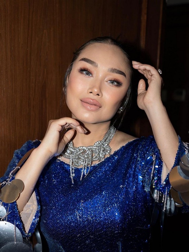 Penyanyi 57 tahun ini mengaplikasikan makeup yang menonjolkan tulang pipi dan bibir bervolume. Dia juga menggunakan teknik contouring untuk memberi kesan pipi tampak tirus dan tulang pipi tinggi. Foto: Instagram/@ti2dj