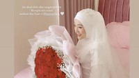 Larissa Chou anggun menggunakan baju pengantin muslimah serba putih. Buket mawar besar diberikan oleh Ikram Rosadi untuk sang istri. Foto: Instagram/@larissachou