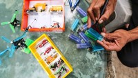 Timan memanfaatkan limbah korek gas dari sampah Kali Utan Kayu untuk dijadikan miniatur kendaraan.