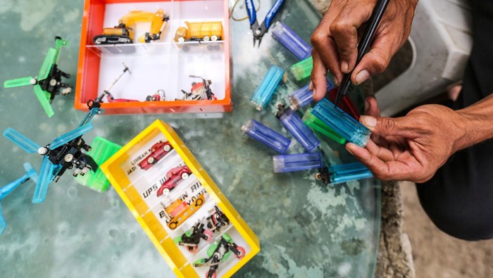 Manfaatkan limbah korek gas menjadi miniatur Timan menata kerajinan miniatur dari limbah korek gas di Pos UPS Badan Air kali Utan Kayu, Kemayoran, Jakarta, Minggu (3/9/2023). Timan seorang Petugas Unit Pengelola Sampah (UPS) Badan Air Dinas Lingkungan Hidup (DLH) DKI Jakarta memanfaatkan limbah korek gas dari sampah Kali Utan Kayu untuk dijadikan miniatur kendaraan seperti truk, sepeda motor dan helikopter. ANTARA FOTO/Asprilla Dwi Adha/YU